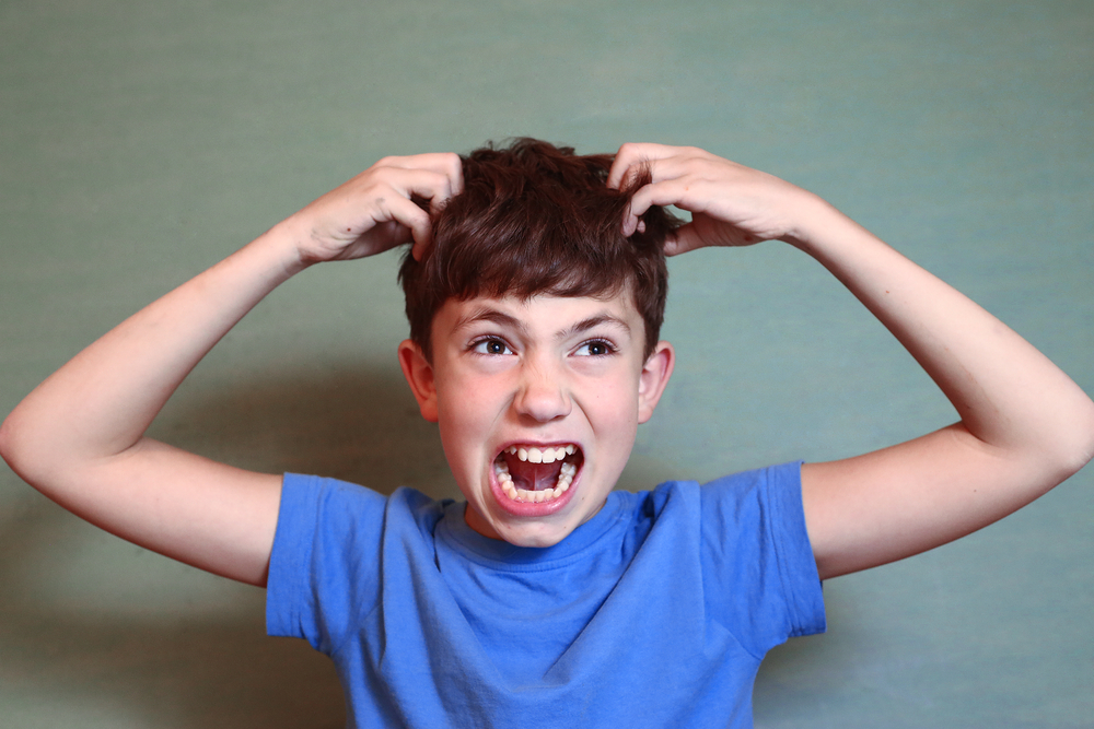 boy scratching head from lice